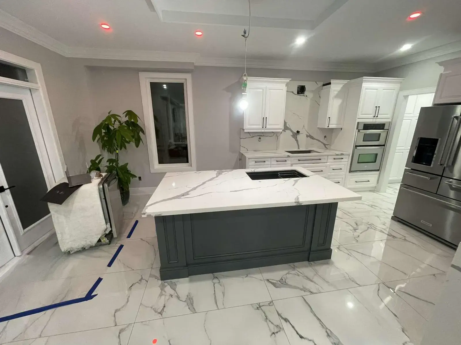 Kitchen renovation in progress with a new island and porcelain floor
