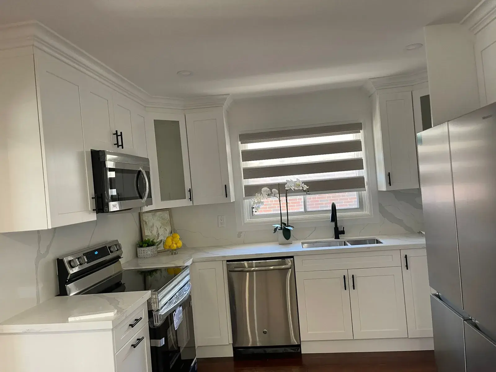 Renovated kitchen with white shaker cabinets and quartz countertops