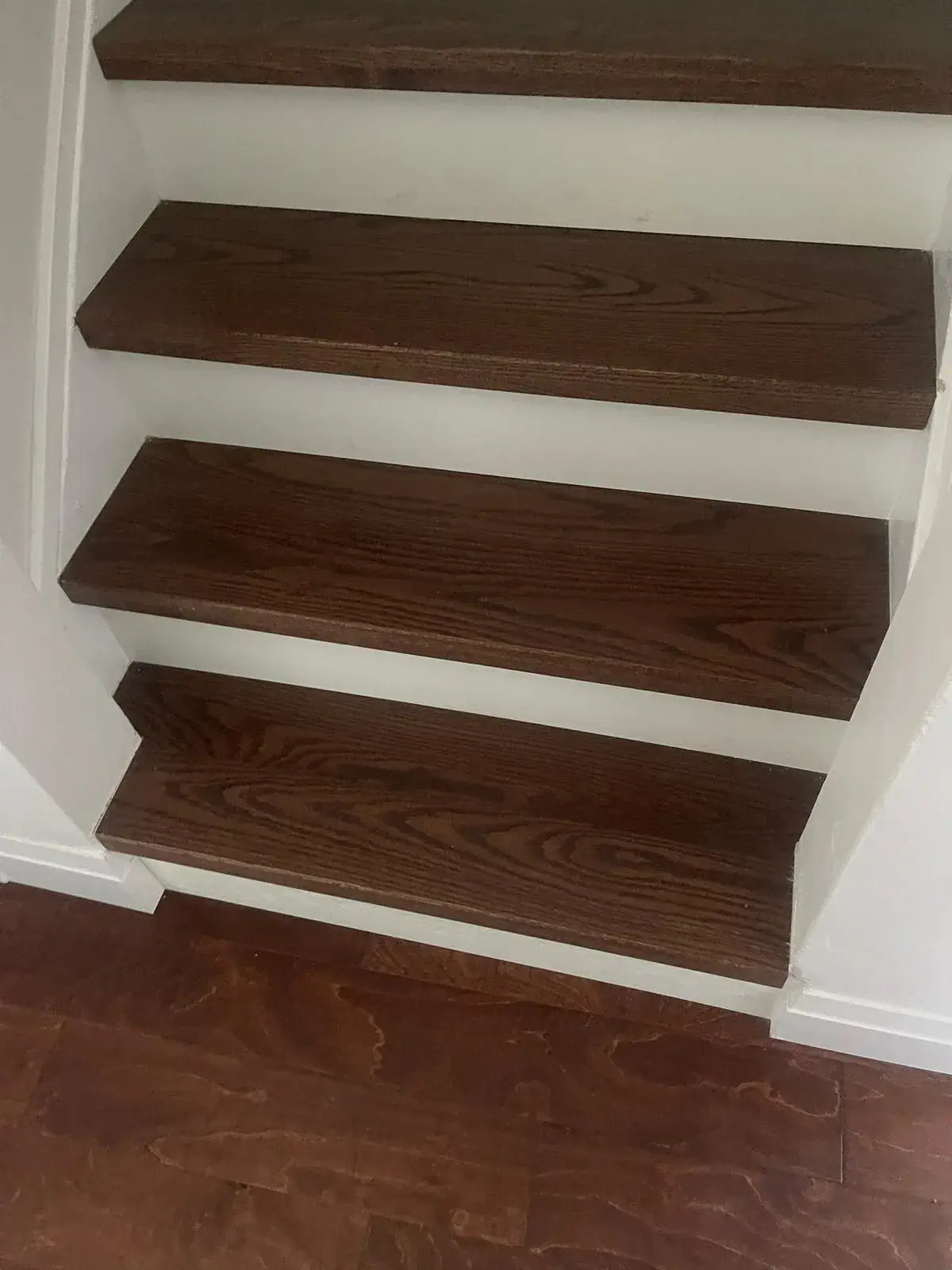 Dark-stained hardwood stair treads after renovation